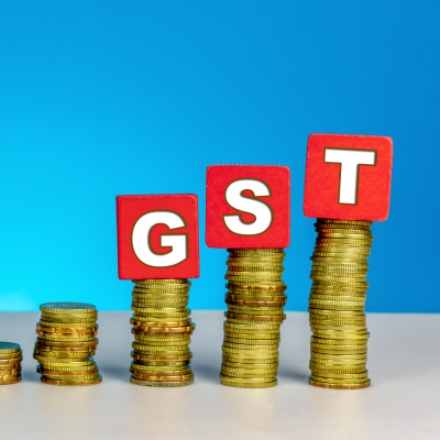 The image likely depicts a visual representation of the Goods and Services Tax (GST) system. It might include a diagram illustrating the flow of GST from the manufacturer or service provider to the consumer, highlighting the various stages of taxation and the role of government authorities. The image could also feature symbols or icons representing different aspects of GST, such as the GST Council, tax invoices, or tax returns. The overall goal is to visually explain the concept of GST and its impact on businesses and consumers. Stock market blogs